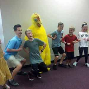 Children Clucking next to a Big Yellow Chicken