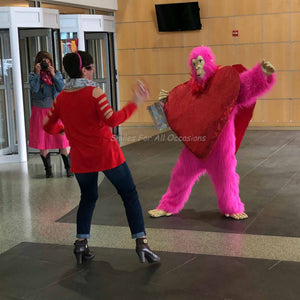 Pink Gorilla with Large Red Heart on Chest Dancing with a Woman